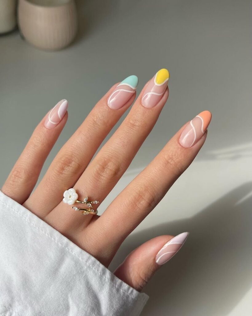 Spring Nail Ideas using pastel rainbow tips with abstract white line art on a nude base.