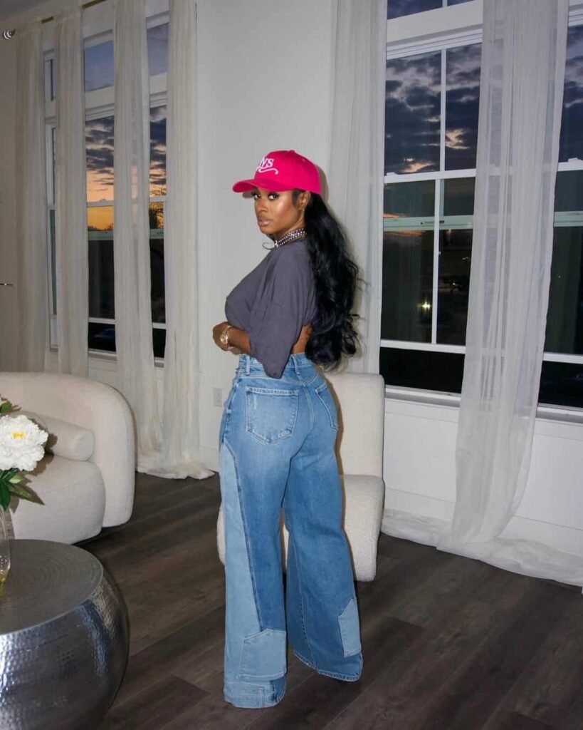 Edgy wide leg pants outfit with patchwork denim jeans, a loose charcoal crop tee, and a bold pink cap.