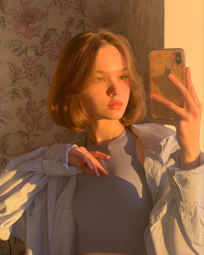 Cute Hairstyles for Short Hair with a full rounded bob, styled with curtain bangs and glowing in soft golden hour lighting.