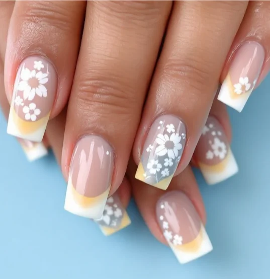 Yellow and white French tip acrylic nails with hand-painted daisy flowers on a natural base