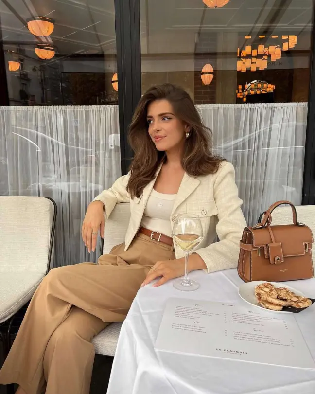 Old money-inspired spring outfit with beige blazer, wide-leg trousers, and a neutral handbag.
