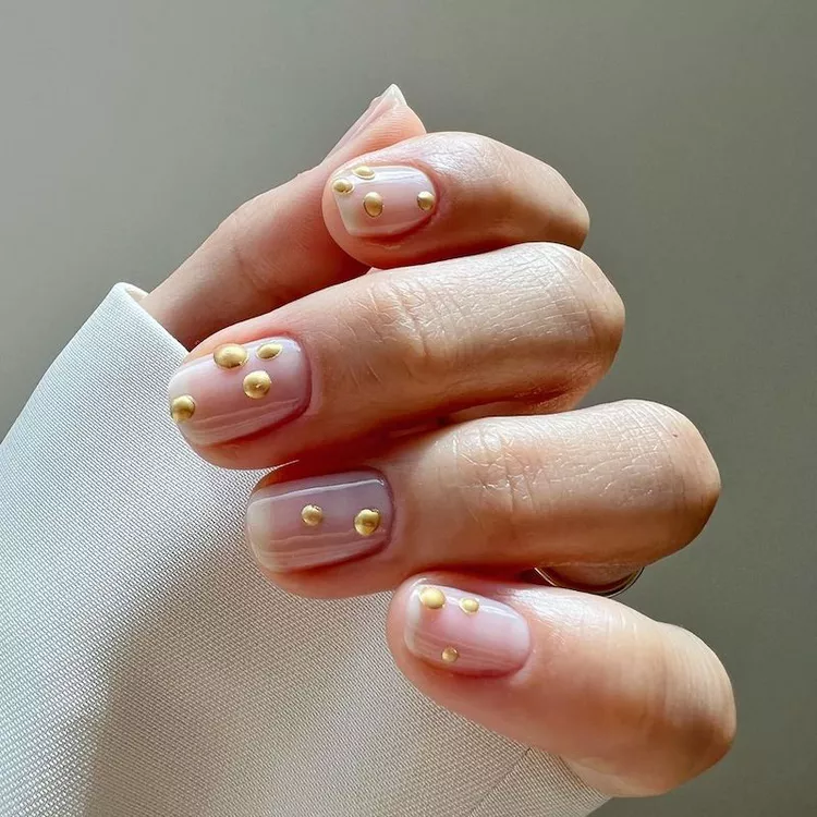 Stunning Nail Ideas featuring a minimalist nude base with glossy finish and gold 3D dot accents for a luxe, modern look.