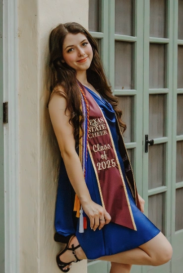 Graduation outfit ideas – royal blue dress with maroon and gold graduation stole, styled with long curls and strappy black heels for a polished celebration look.