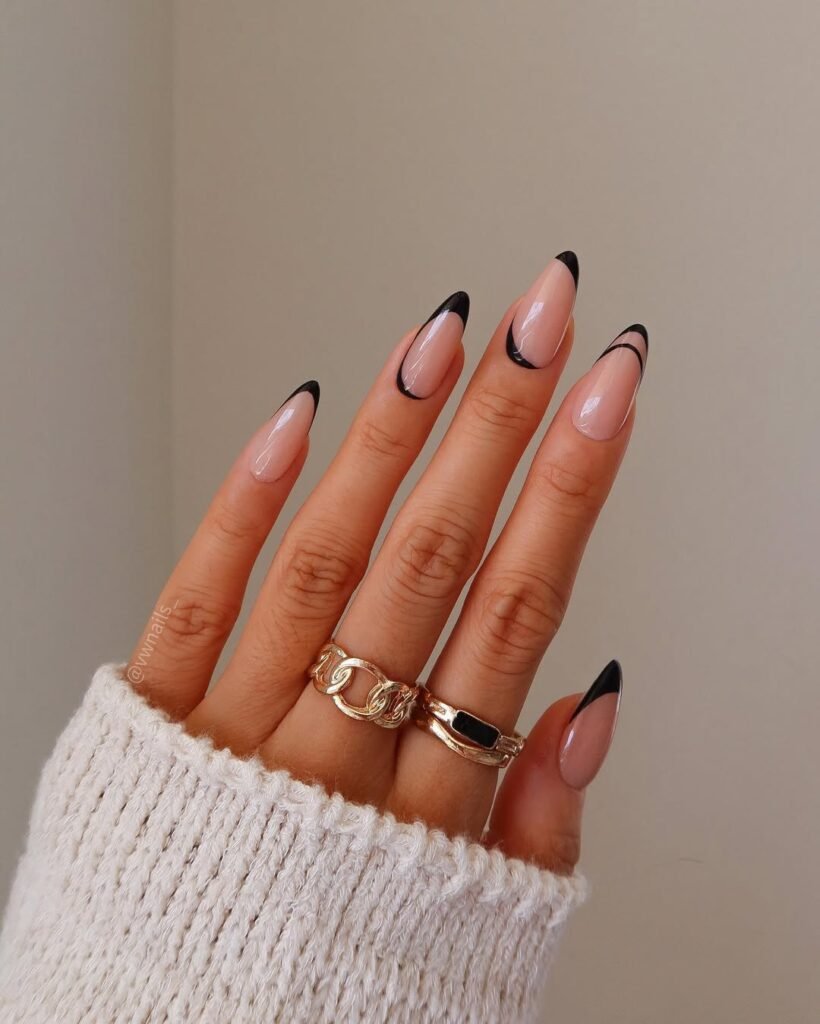 Minimalist Stunning Nail Ideas with nude base and sharp black French tips, outlined by thin swooping curves for a sleek, modern twist.