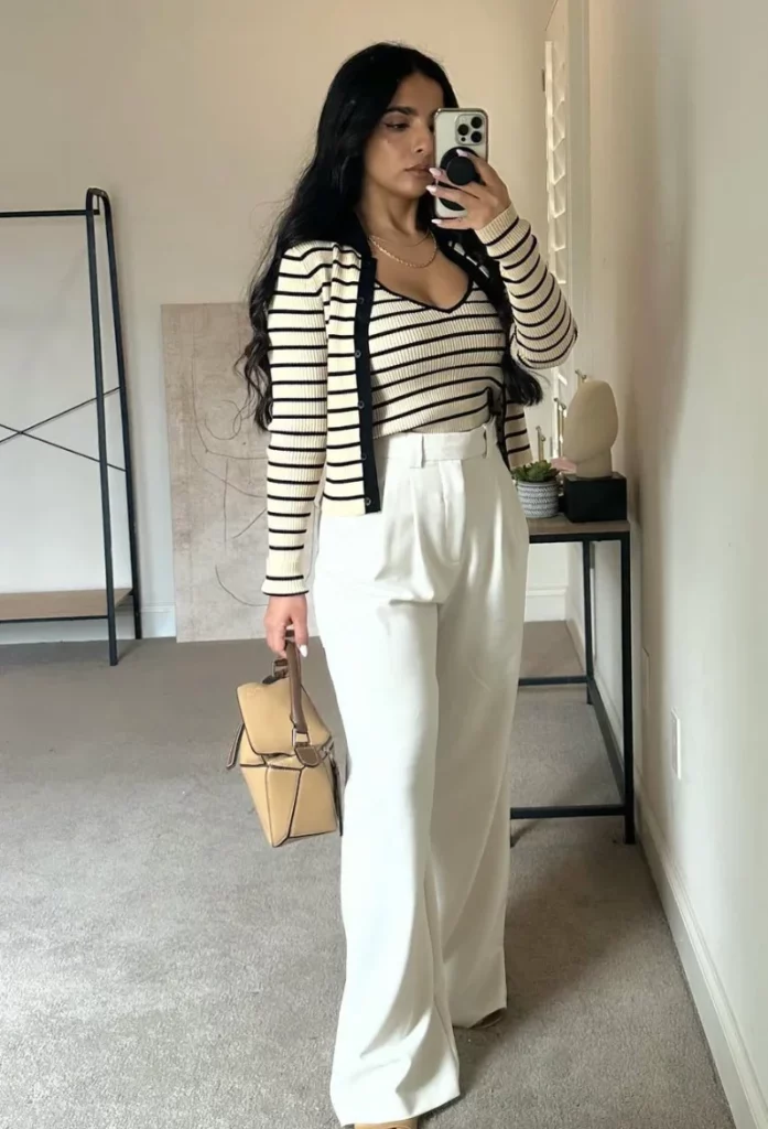 Trendy White Pants Outfits showcasing wide-leg white trousers styled with a striped fitted top, matching cardigan, and beige handbag.