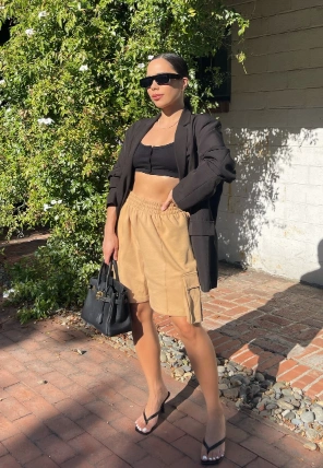 Cargo Shorts Outfits: Sophisticated and casual mix with tan drawstring cargo shorts, a black crop top, blazer, and sunglasses.