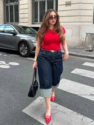 European Summer Outfit pairing a fitted red top with dark cuffed denim capri pants, red pointed heels, and a black handbag.

