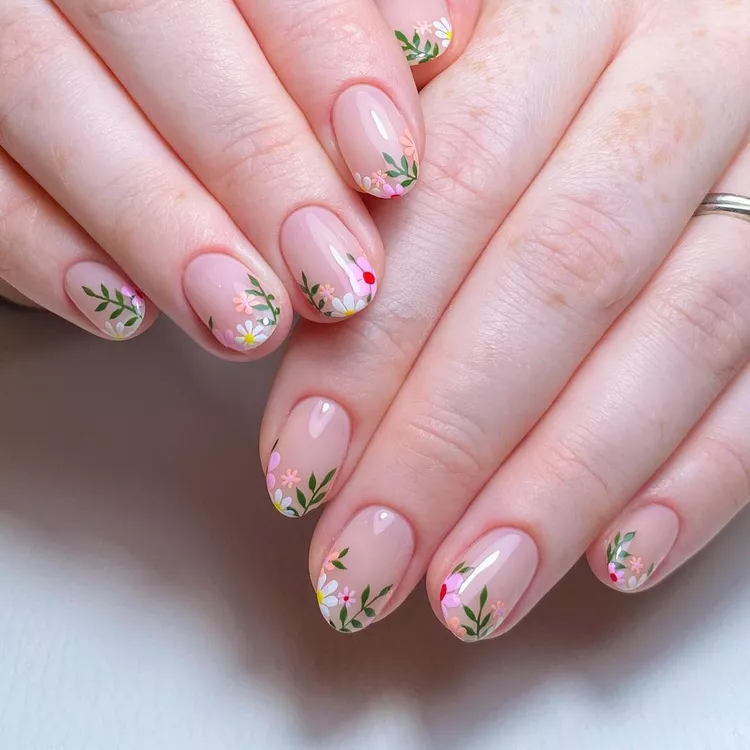 Elegant Stunning Nail Ideas showcasing hand-painted wildflowers and green leaves on a nude base, creating a garden-fresh vibe.