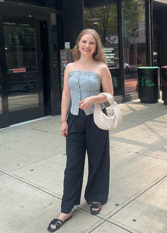 Early Fall Outfit with an urban edge – strapless denim bustier paired with black wide-leg pants and slip-on sandals, finished with a minimalist white shoulder bag.