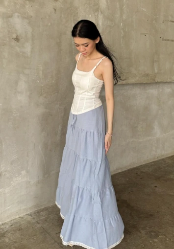 outfit korean style of a white corset-style tank top paired with a tiered light blue maxi skirt.