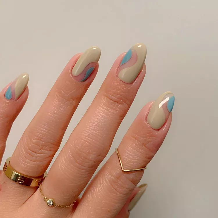Retro-inspired Stunning Nail Ideas with swirly patterns in tan, pink, and blue over a nude almond shape for a modern vintage style.