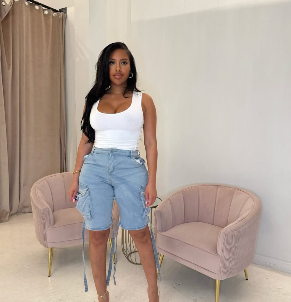 Trendy Cargo Shorts Outfit featuring light-wash denim cargo shorts with tie details and a fitted white tank top, styled for a casual city look.