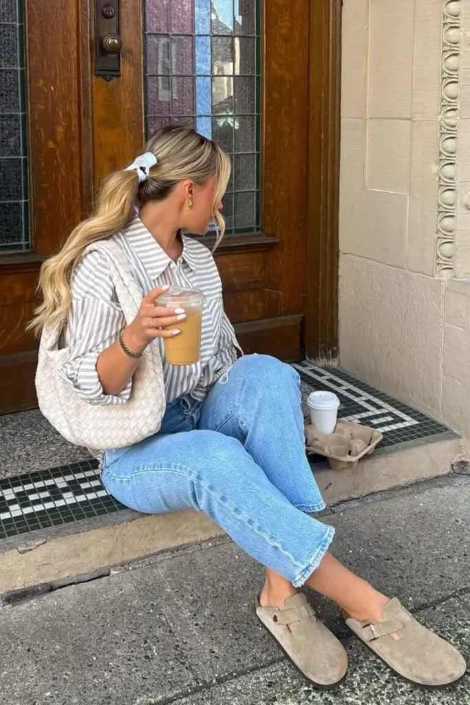 Spring Outfit Ideas with a casual striped shirt, light-wash jeans, and taupe suede clogs, styled with a white scrunchie and woven shoulder bag.