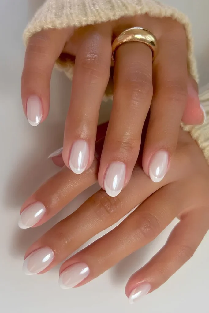White Summer Nails in a natural oval shape with a sheer base and subtle white tips, giving a classic French summer style.