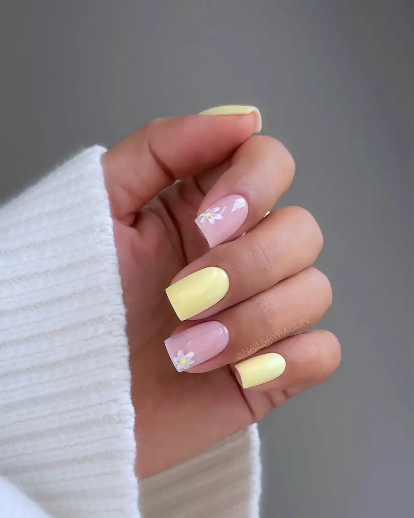 Bright and cheerful Stunning Nail Ideas featuring alternating yellow and pink nails, with dainty daisies on accent fingers for a sweet spring touch.