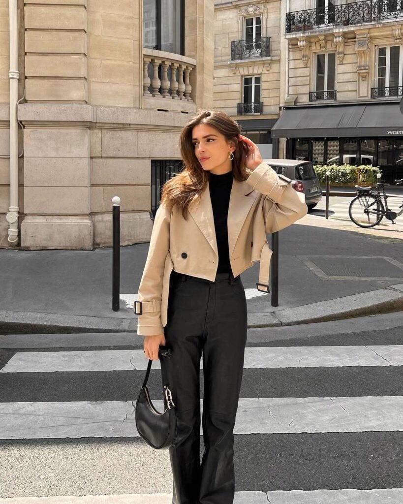 Old Money-Inspired Spring Outfit with a beige cropped trench coat layered over a black top and tailored black pants, paired with a black handbag.