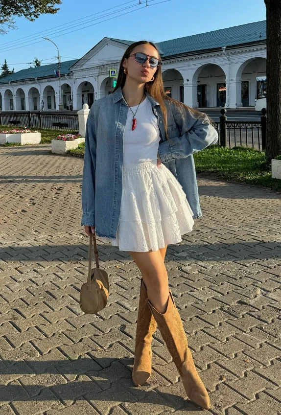 Early Fall Outfit styled with a flowy white mini dress layered under a light denim shirt and finished with tan cowboy boots – perfect for sunny fall afternoons.
