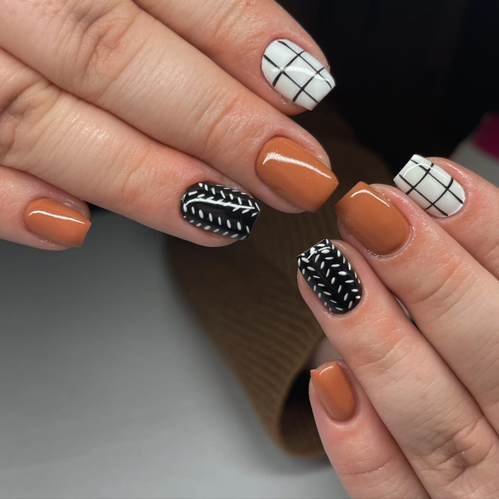 Short fall nail designs in burnt orange, black, and white plaid patterns with sweater knit details.