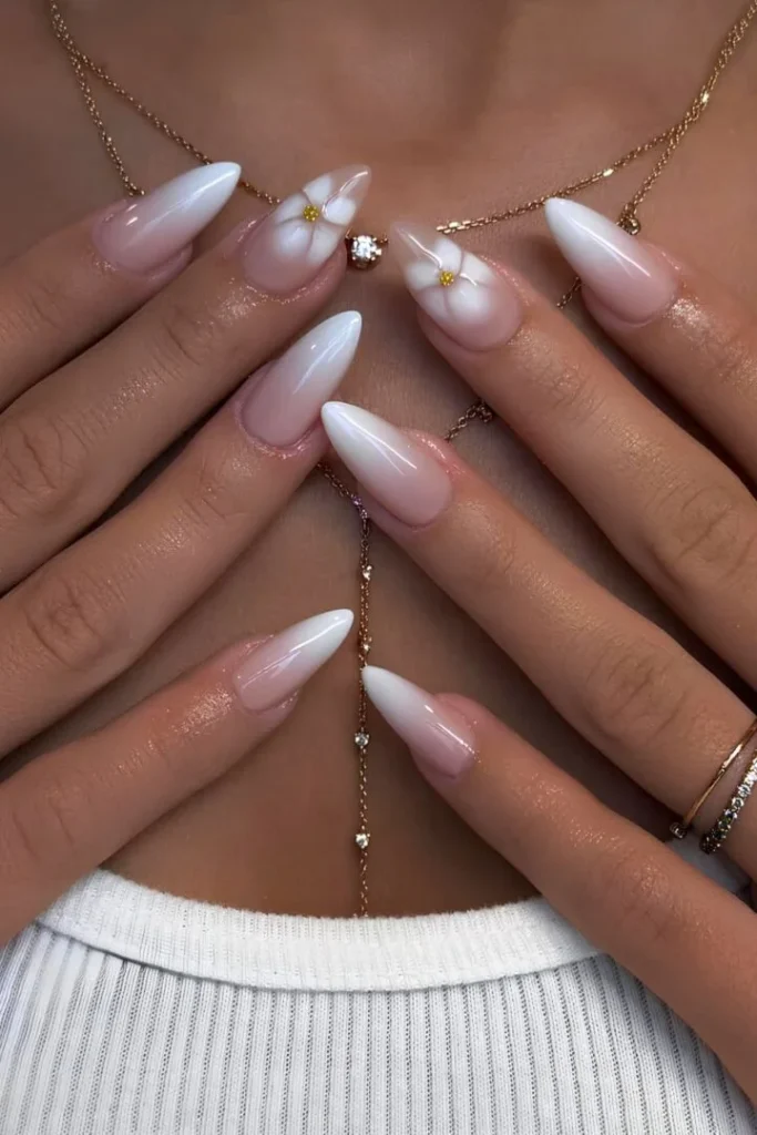 Glamorous stiletto-shaped White Summer Nails with soft ombre and 3D floral accents, ideal for a bold summer statement.