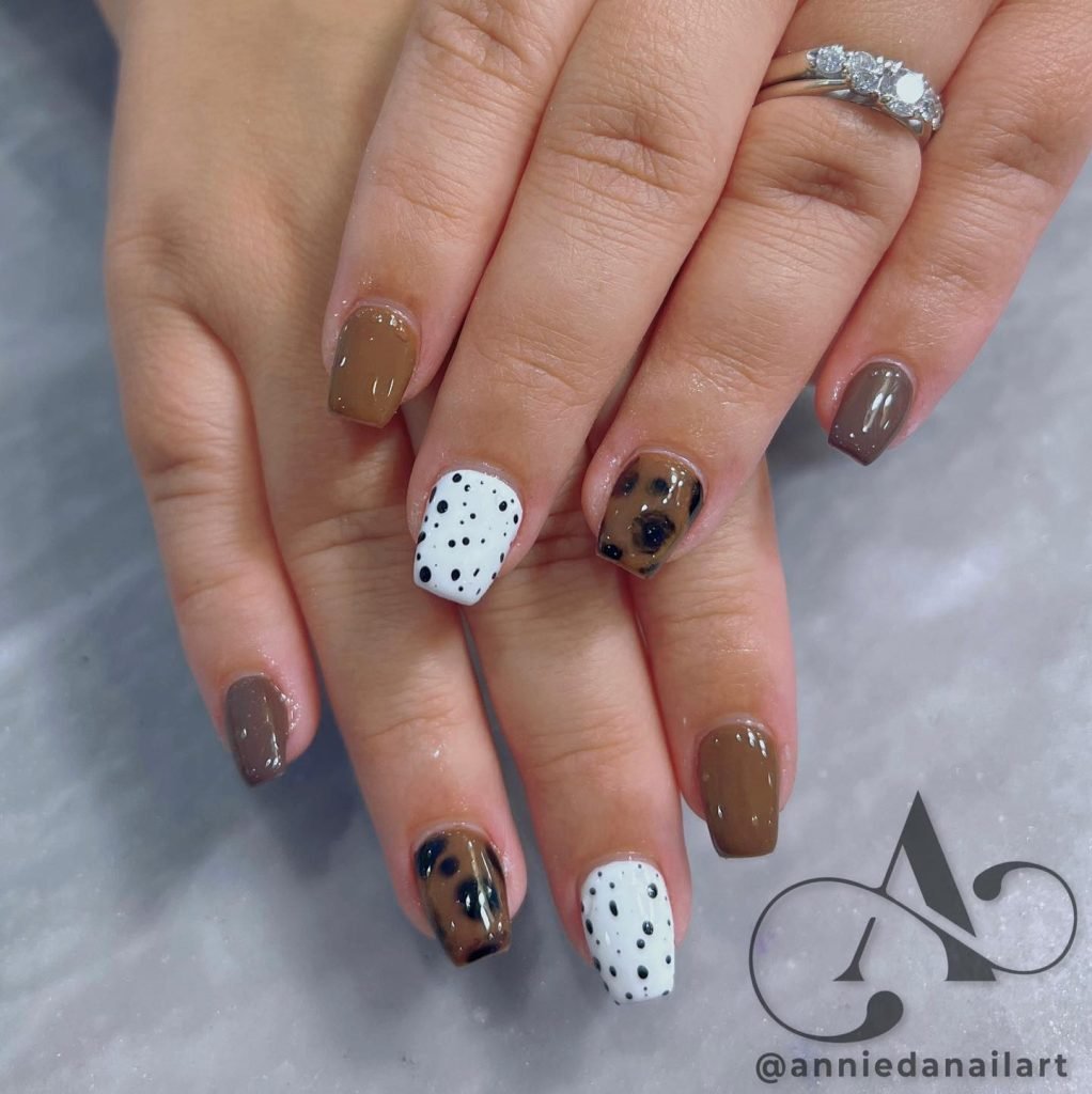 Short fall nail designs in brown, white, and black speckled patterns for a cozy autumn vibe.