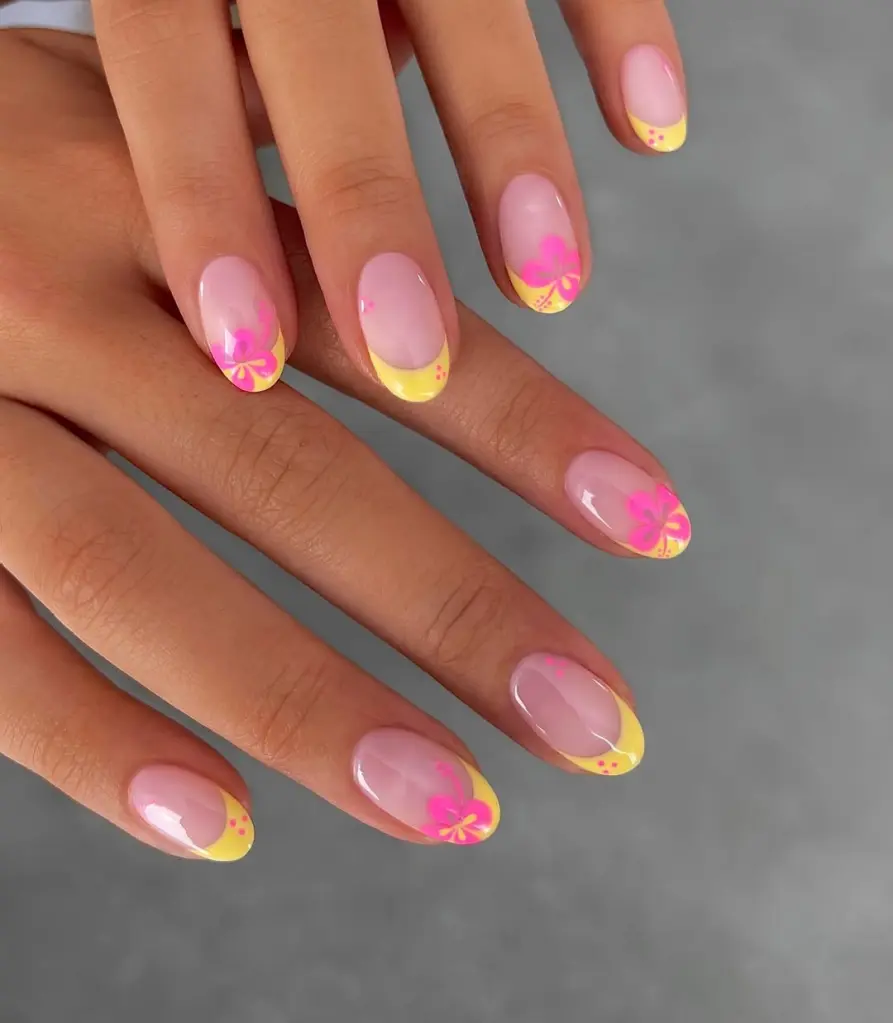 Playful and tropical-inspired Stunning Nail Ideas featuring yellow French tips and pink floral designs on a translucent pink base.