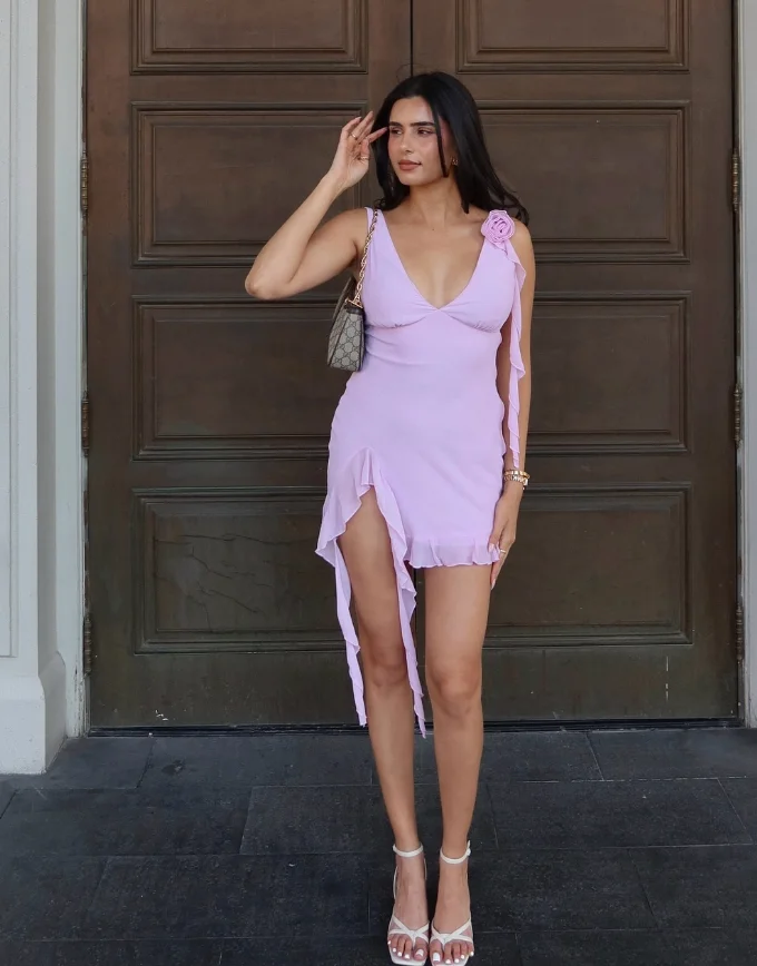 A woman in a light purple asymmetrical mini dress with floral strap detail and heels, showing a dressy twist on cute simple outfits.