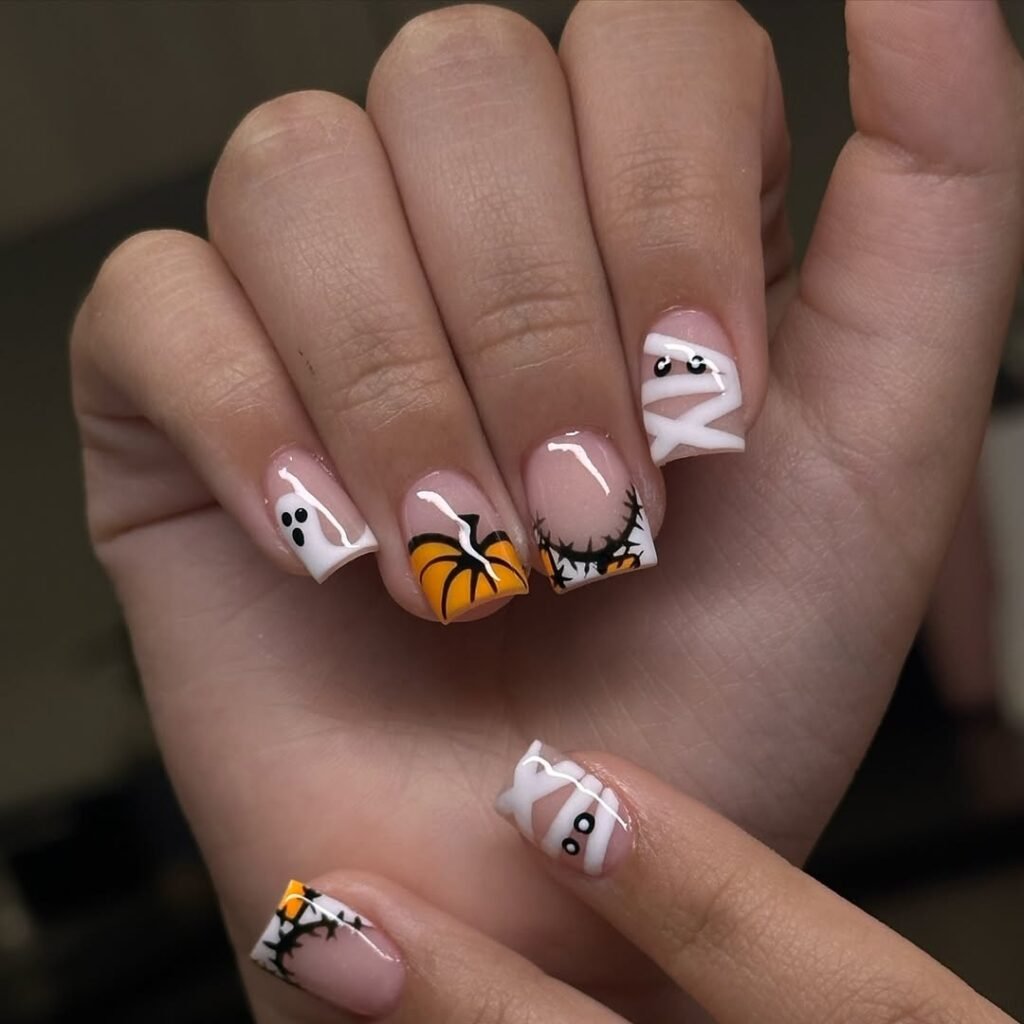 Short fall nail designs with Halloween-themed pumpkin, ghost, and mummy nail art.