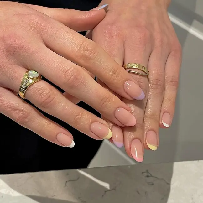 Pastel-themed Stunning Nail Ideas with multicolored French tips on almond-shaped nails, creating a fresh and elegant springtime vibe.