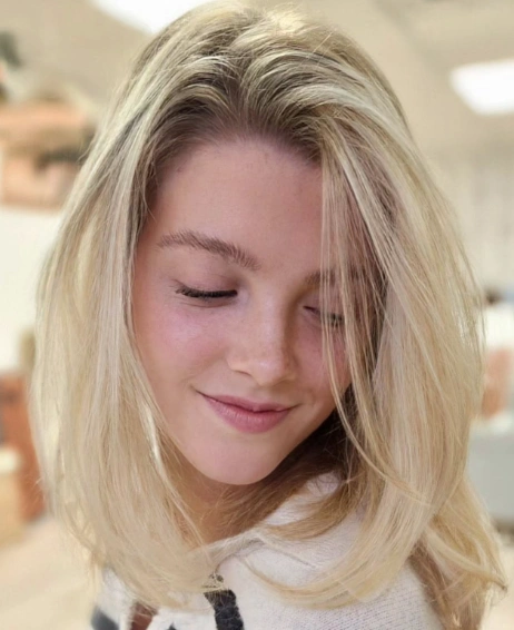 Hairstyles for Medium Length Hair in a bright platinum blonde shade, styled in airy face-framing layers and casual volume.