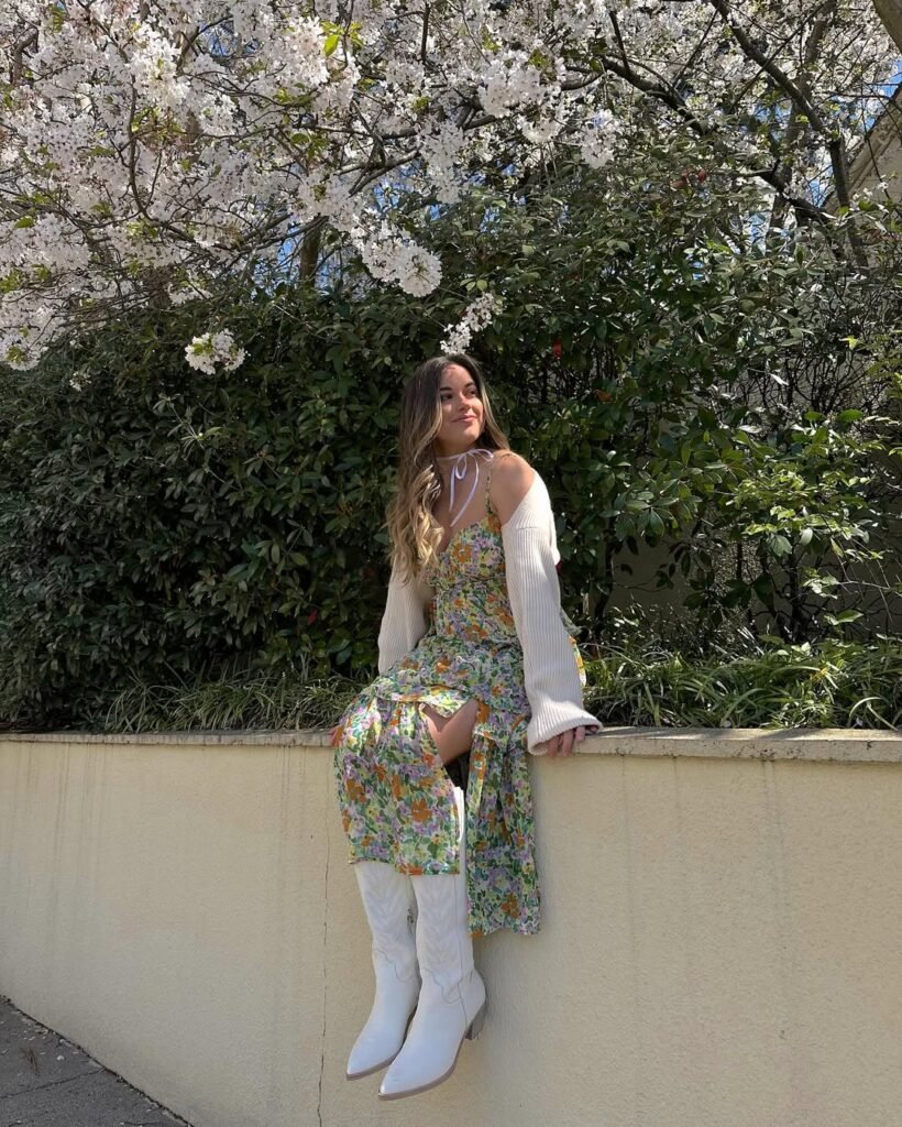 Spring Outfit Ideas in a colorful floral dress paired with a cream cardigan and white western boots, perfect for a bloom-filled spring day.
