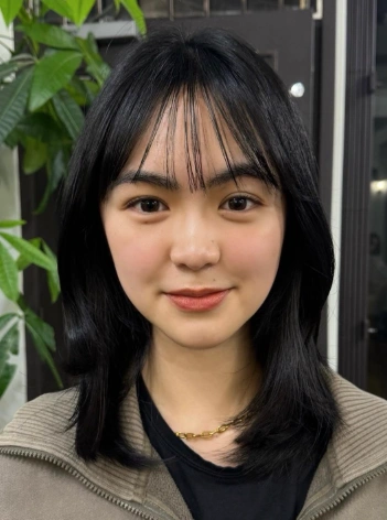 Hairstyles for Medium Length Hair with subtle S-shaped waves and long see-through bangs, giving a youthful and delicate look.