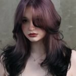 Woman with layered lavender hair blending into jet black ends — a dreamy and mysterious style for Fall Hair Colors.