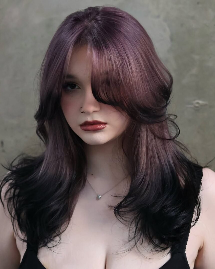 Woman with layered lavender hair blending into jet black ends — a dreamy and mysterious style for Fall Hair Colors.