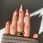 Chic minimalist Fall Nail Colors with leaf accents and gradient French tips in neutral tones.