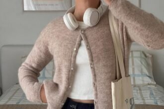 Casual cardigan outfit with a light brown fuzzy cardigan and navy shorts, accessorized with headphones and a tote bag.