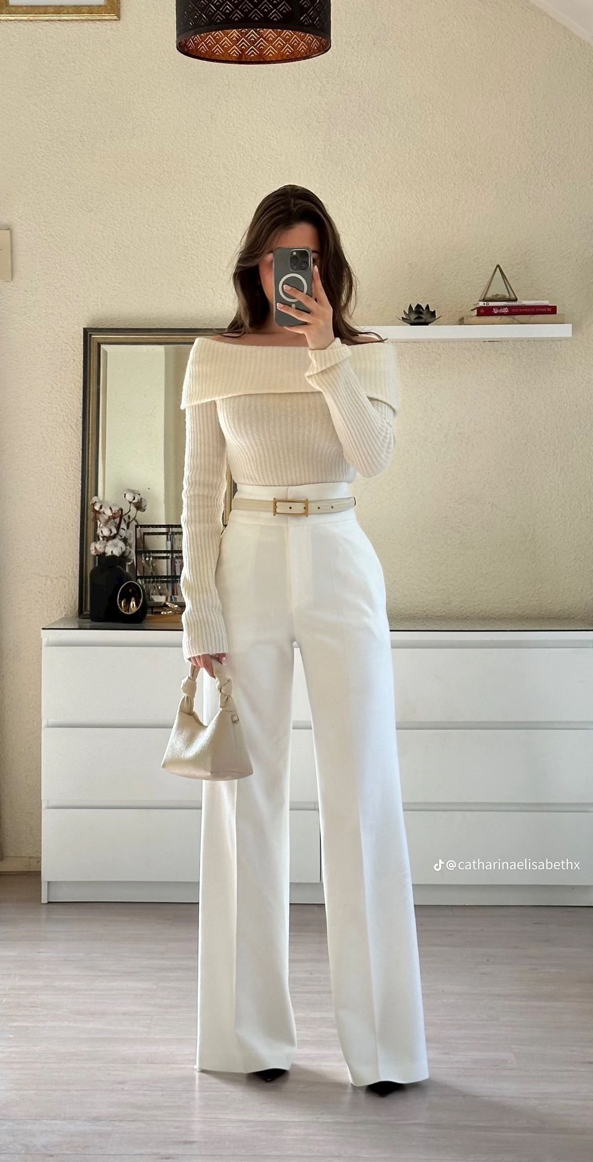 Stylish work attire in a monochromatic cream palette with wide-leg trousers, an off-shoulder ribbed knit top, and a matching belt, styled with a mini handbag for a soft, sophisticated office outfit.