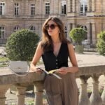 Modern stylish work outfit with black vest top and tailored tan trousers.