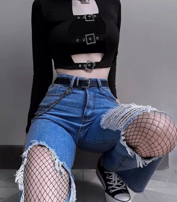 Grunge Outfits: Person with long red hair wearing a black lace-up halter crop top, black flared pants, and platform shoes standing on a city street.