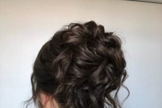 Elegant hairstyle in a tousled, textured updo with romantic face-framing tendrils.