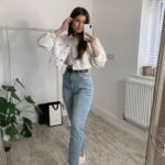 Light denim jeans and a cropped white jacket paired with white sneakers for a crisp everyday outfit. Outfits Casuales.