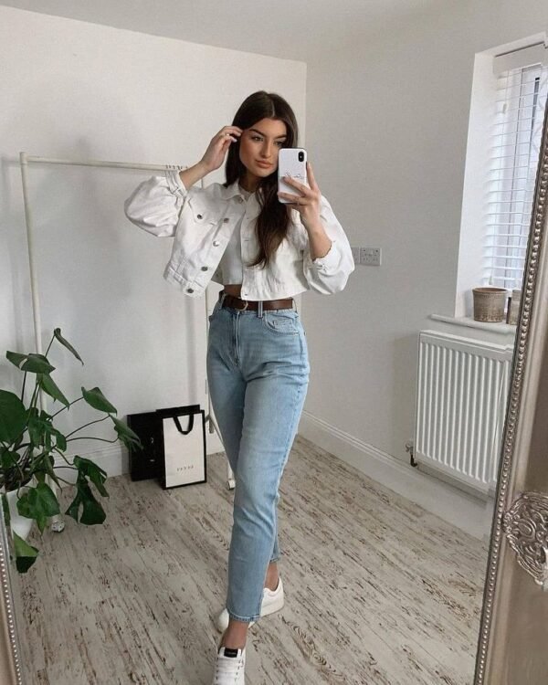 Light denim jeans and a cropped white jacket paired with white sneakers for a crisp everyday outfit. Outfits Casuales.
