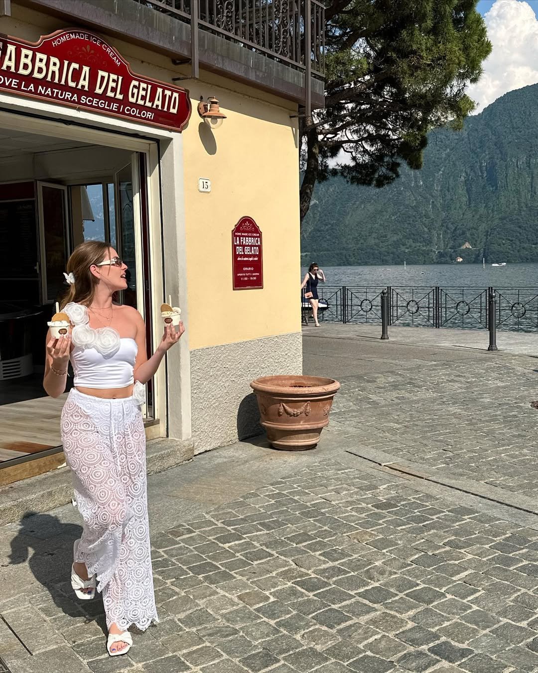 Playful Summer Outfits with a unique white floral top and sheer lacy pants, captured while enjoying ice cream by the lake.
