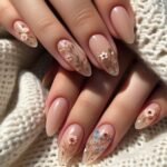 Neutral summer nails featuring delicate wildflower art over a nude base, with a soft almond shape for an earthy romantic vibe.