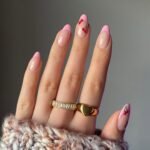 Spring Nail Ideas with pink French tips and playful cherry fruit nail art on a natural pink background.