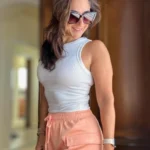 Cargo Shorts Outfits: Bright and playful summer look with salmon pink cargo shorts and a white tank top.