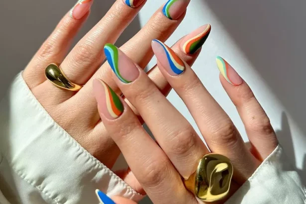 Bold and colorful Stunning Nail Ideas with abstract rainbow waves on almond-shaped nails, ideal for vibrant and creative styles.