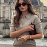 Elegant woman by a European riverfront in a taupe short-sleeve knit top and a plaid pencil skirt, embracing a timeless Old Money Outfit style.